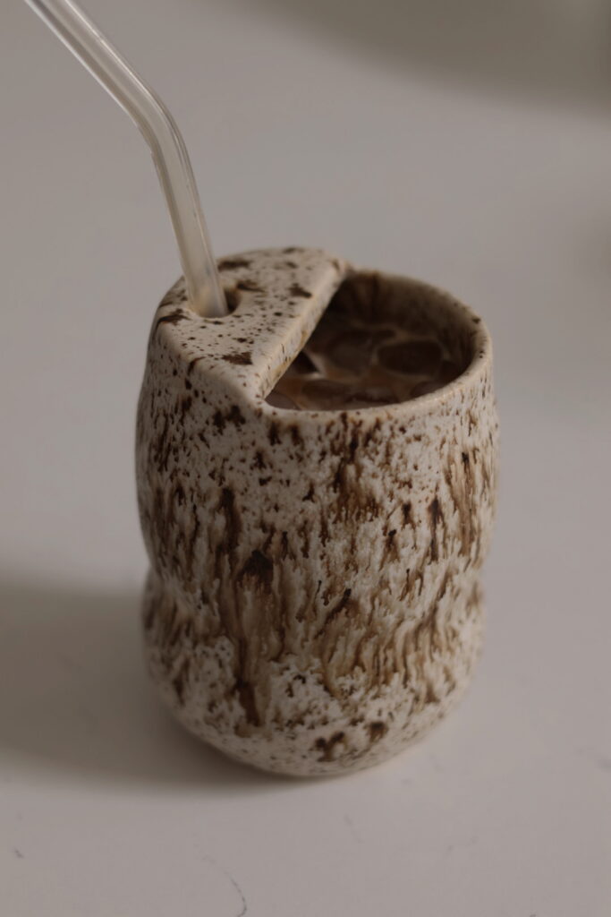 unique ceramic tumbler with a spout opening and a glass straw 